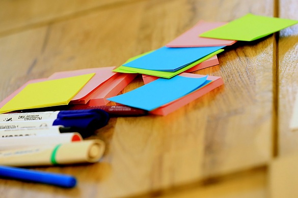 Verschiedene Stifte und bunte Zettel auf einem Tisch
